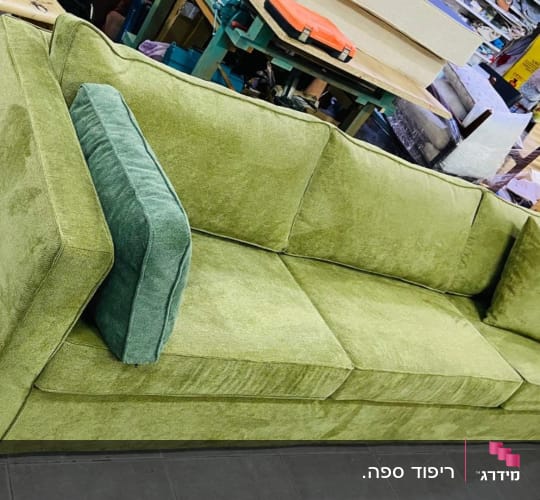 ספה ירוקה עם כריות מרופדות בחנות רהיטים